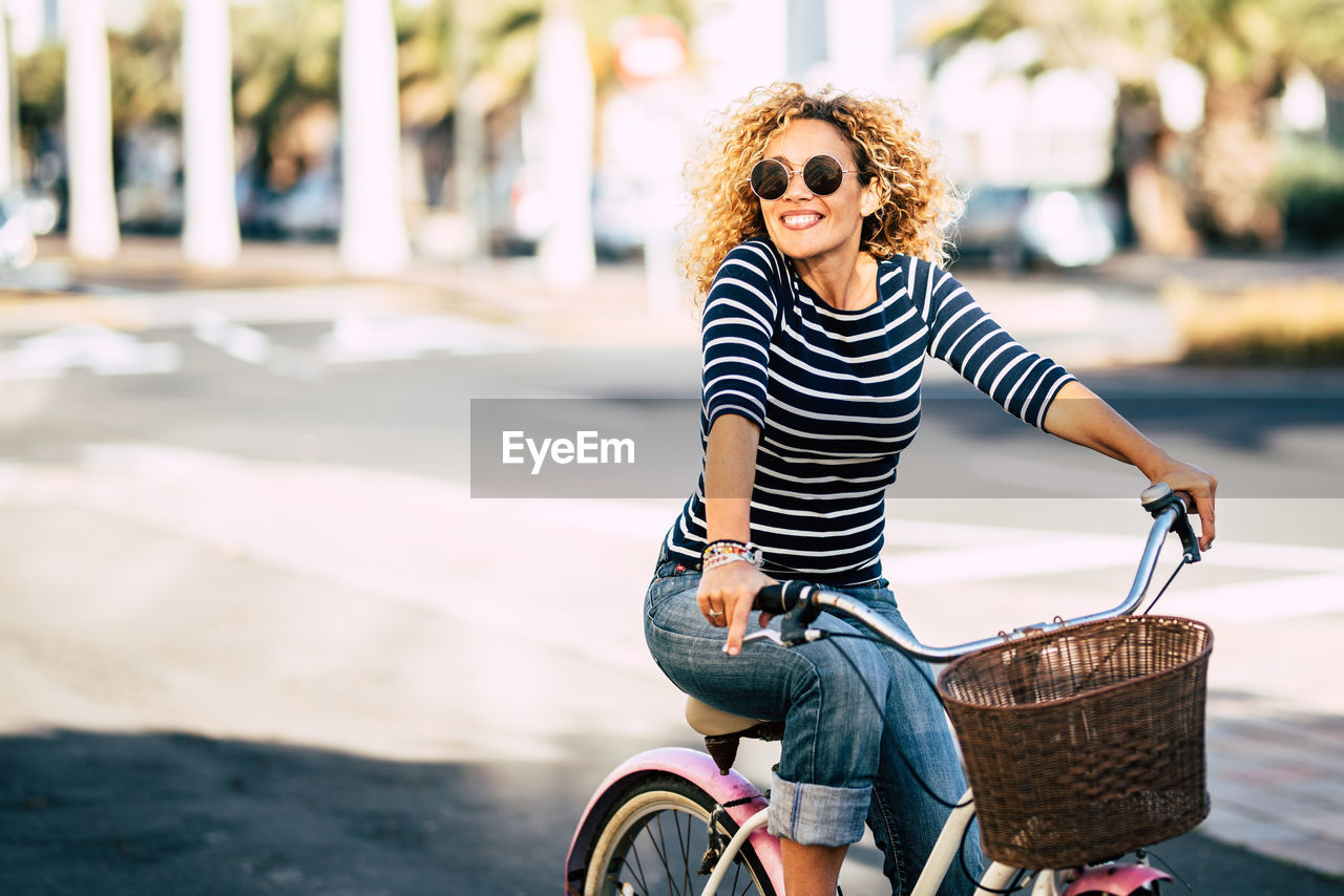 Smiling woman riding bicycle in city