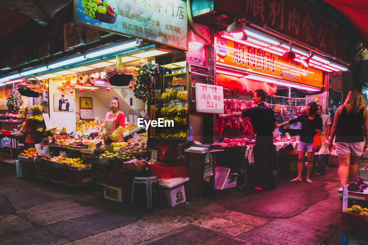 PEOPLE AT MARKET STALL IN CITY