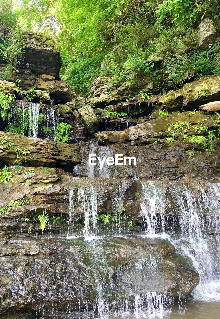 RIVER FLOWING THROUGH ROCKS IN FOREST