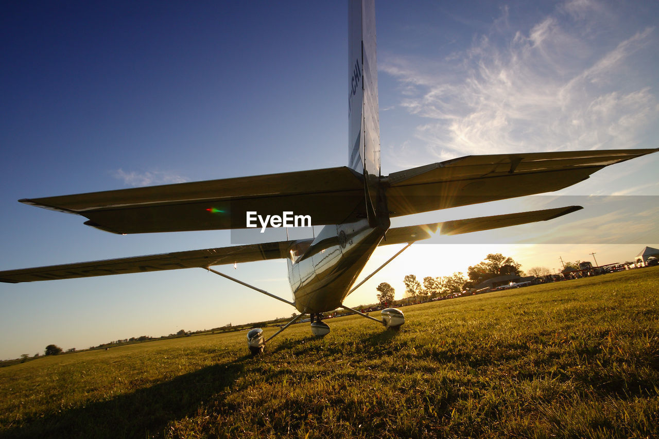 AIRPLANE ON FIELD AGAINST SKY