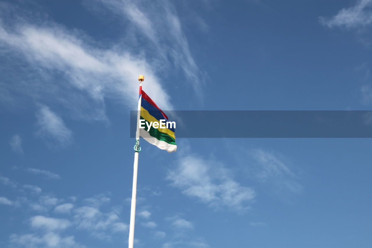 Low angle view of colorful flag against sky