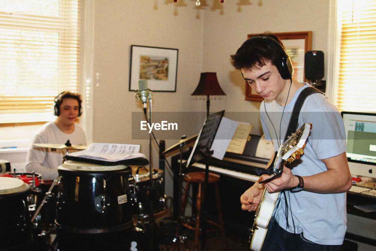 Young men playing music while practicing at home