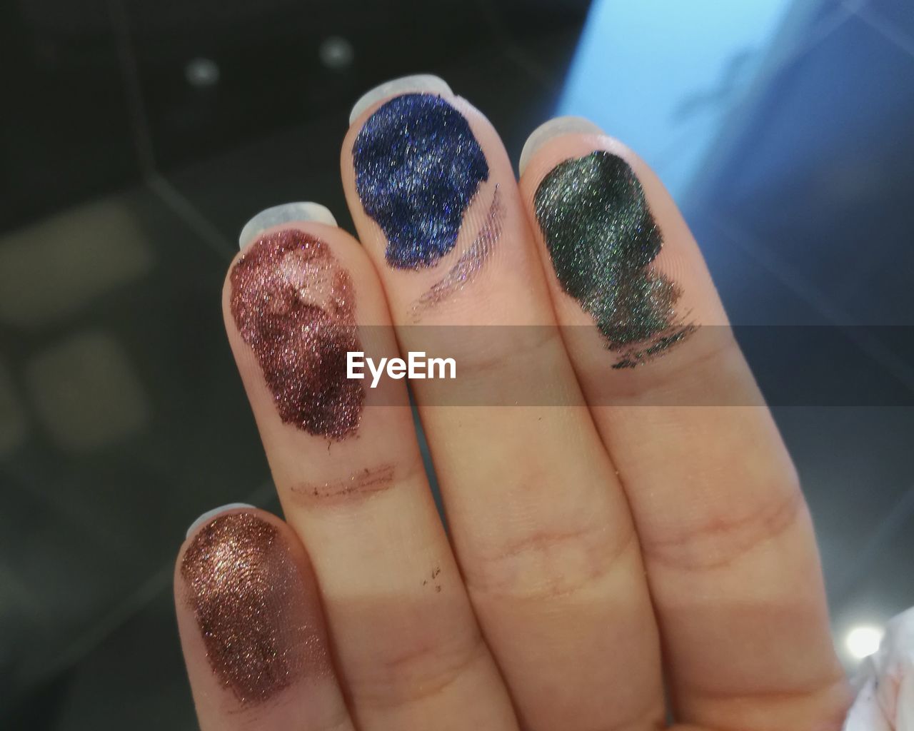 Cropped hand of woman with colorful glitter