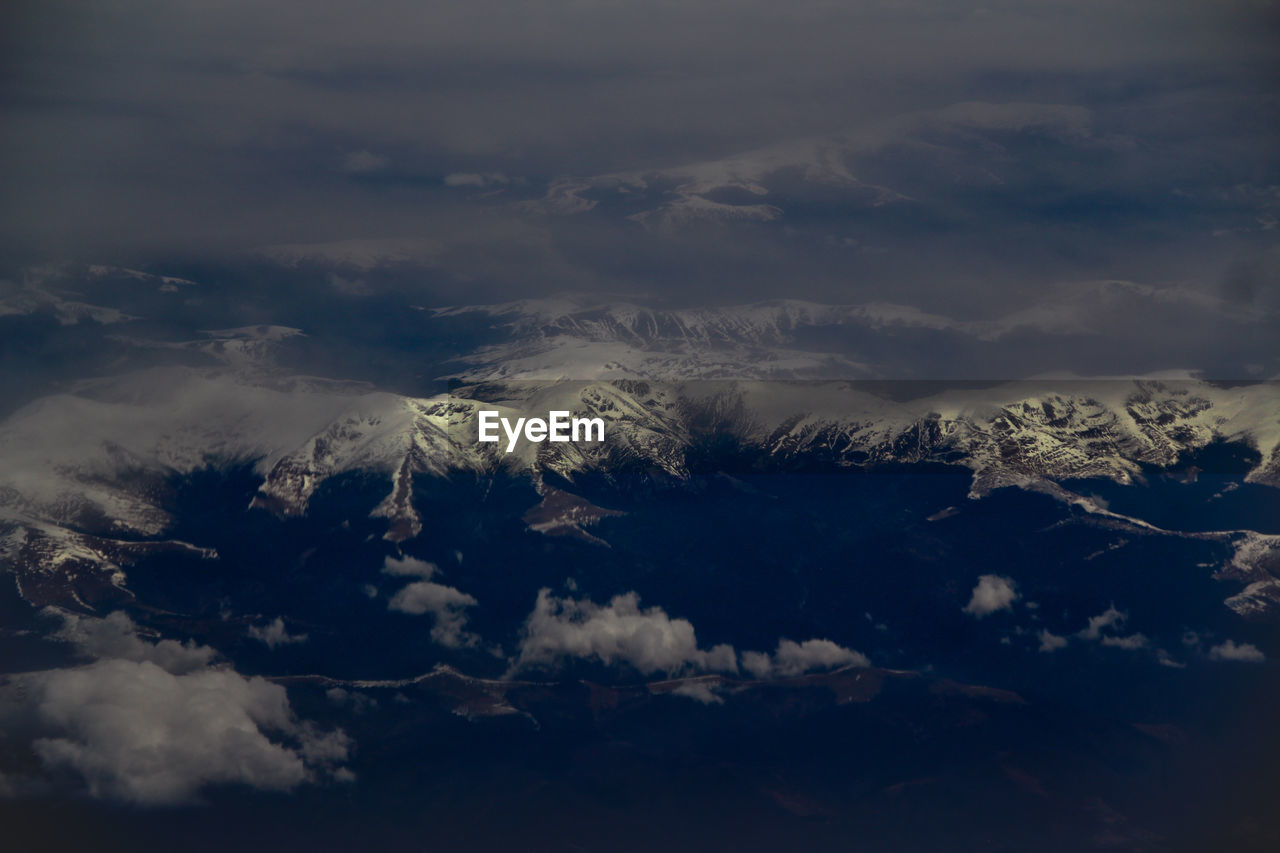 Scenic view of silhouette mountains against sky during winter