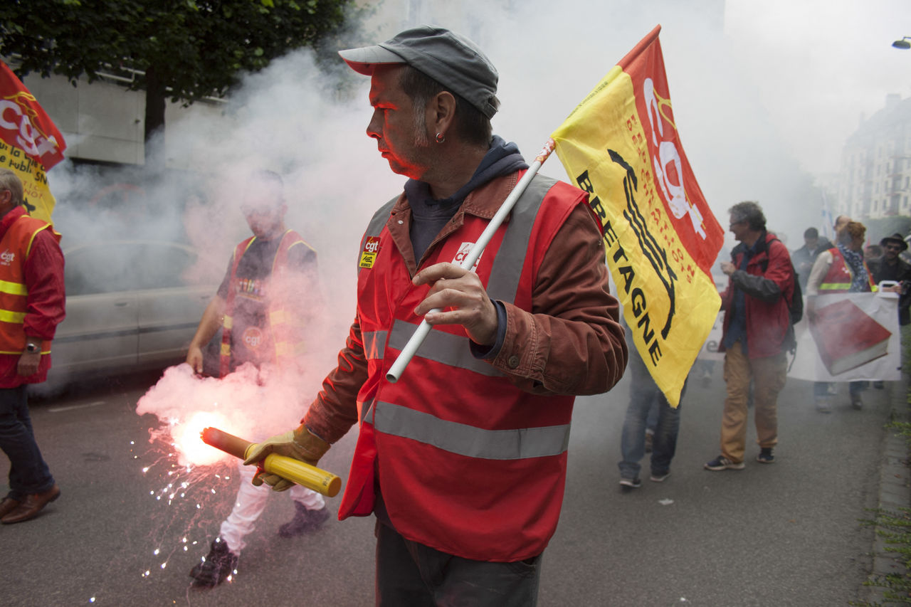 smoke, burning, men, fire, group of people, adult, clothing, holding, firefighter, festival, occupation, celebration, standing, event, street, day, crowd, nature, city, tradition, outdoors, person, heat, flame