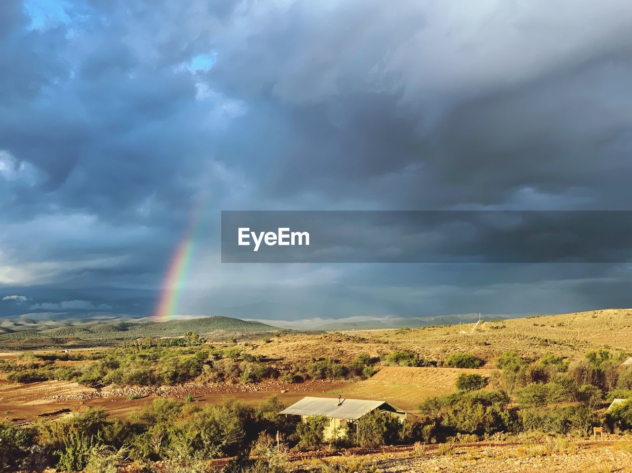 Scenic view of rainbow over land against sky