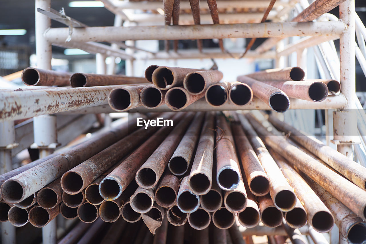 Close-up of rusty pipes on shelf