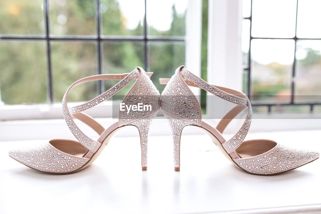 Close-up of shoes on table against window