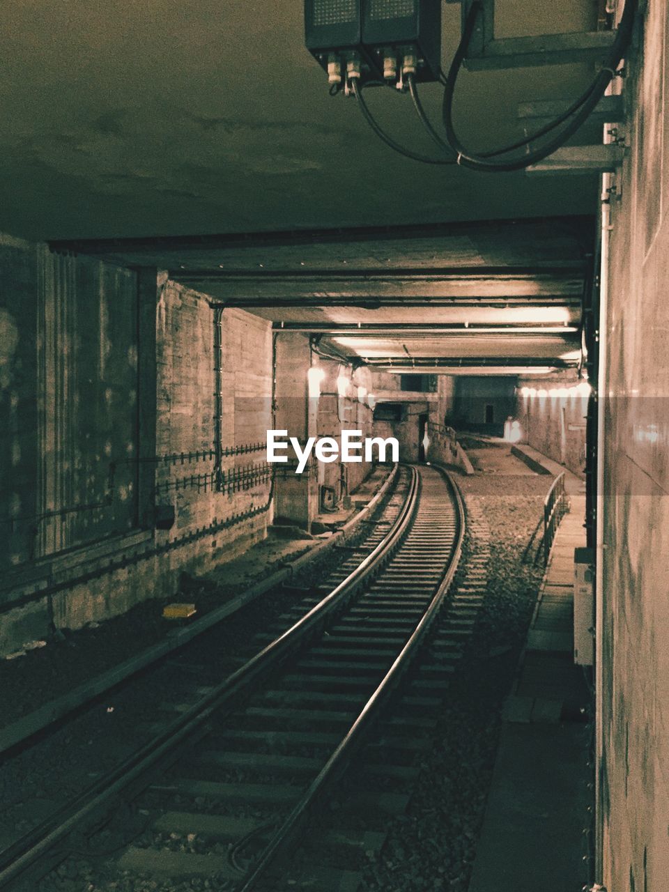 RAILROAD TRACK IN ILLUMINATED UNDERGROUND WALKWAY