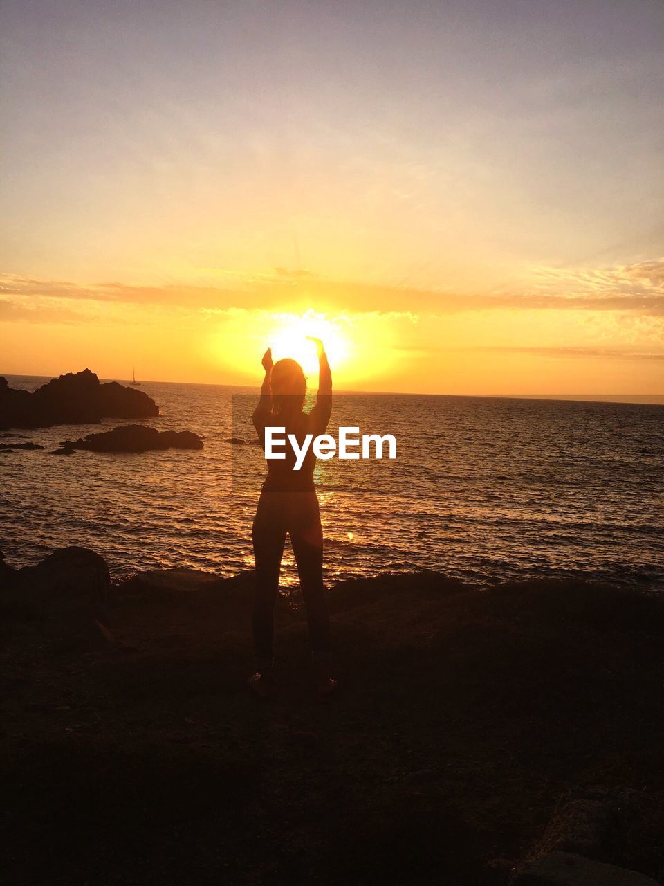 Silhouette  standing on beach against sky during sunset