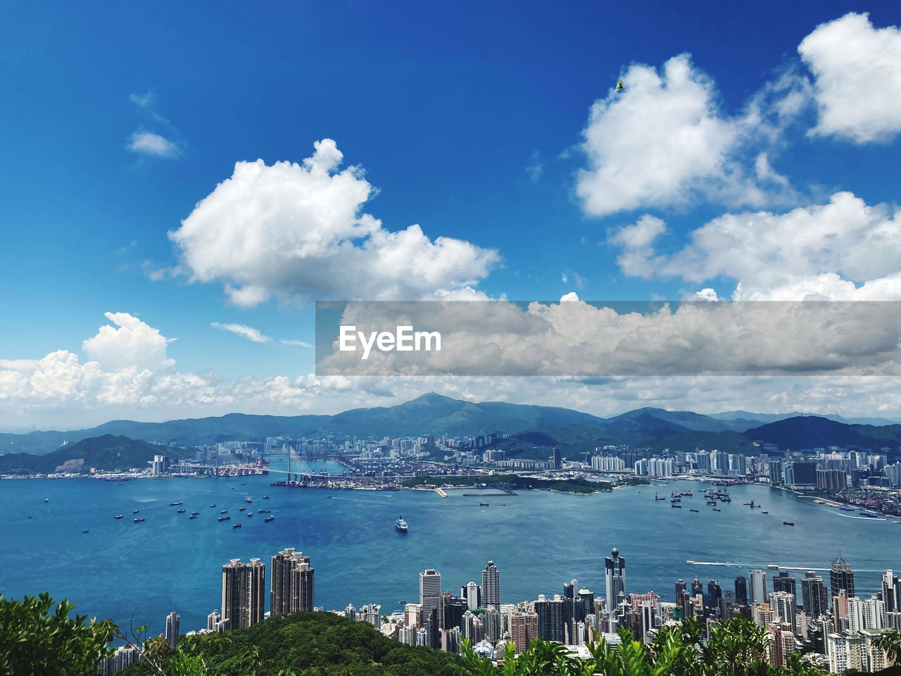 Scenic view of victoria harbour against cloudy sky