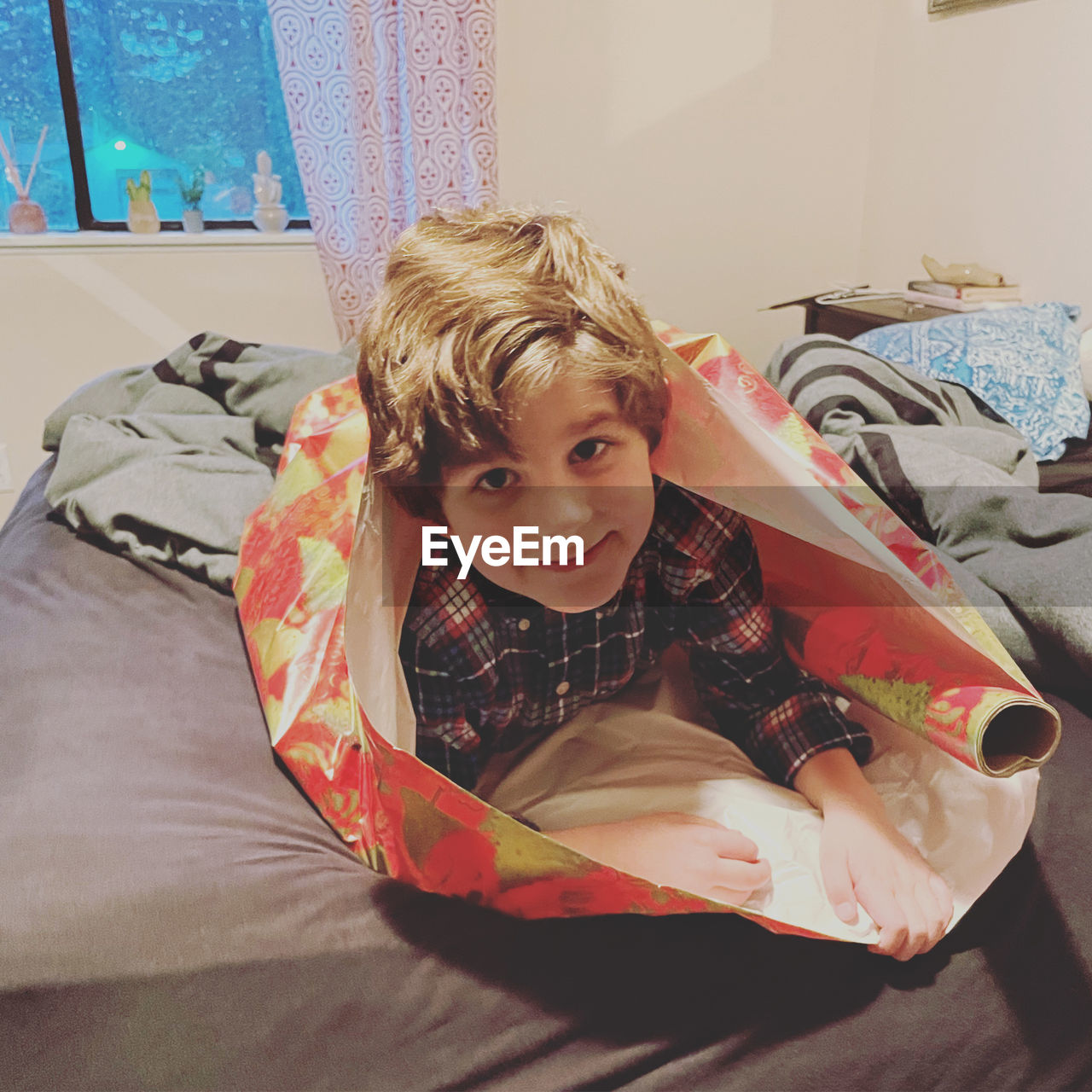 PORTRAIT OF CUTE BOY LYING IN BED