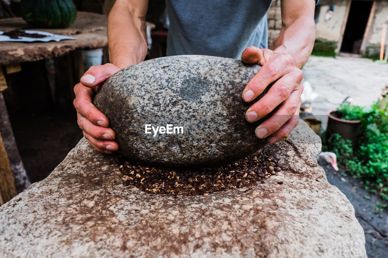 MIDSECTION OF MAN HOLDING ROCKS