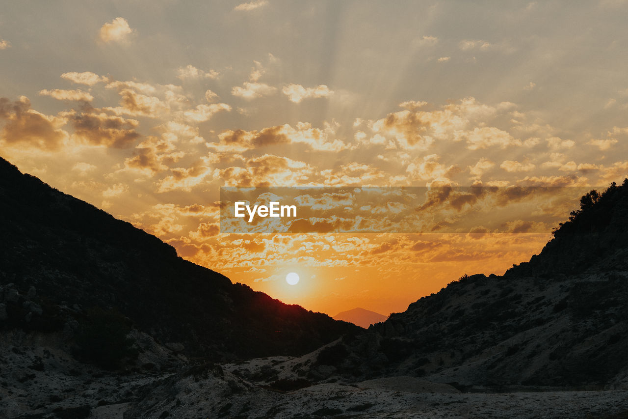 Scenic view of silhouette mountains against sky during sunset