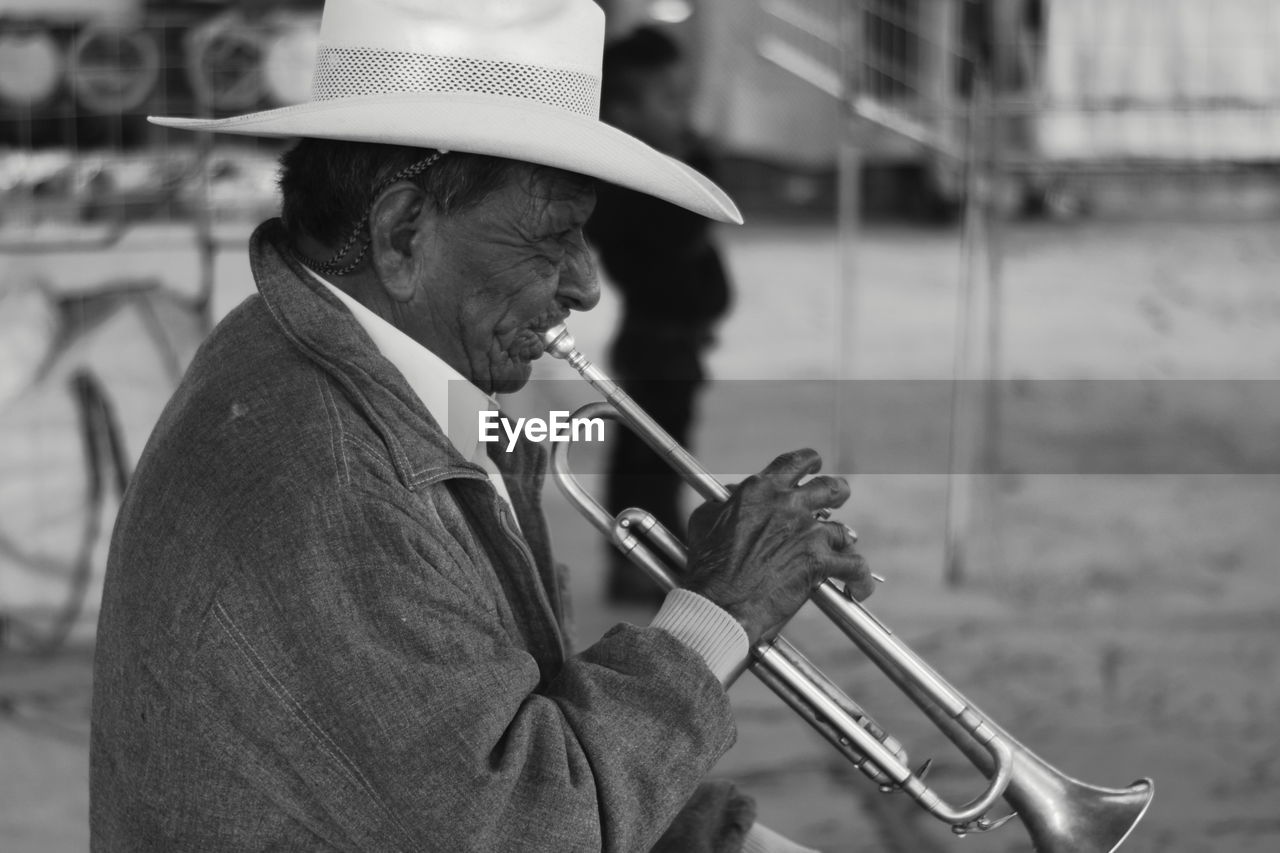 Senior man playing trumpet outdoors