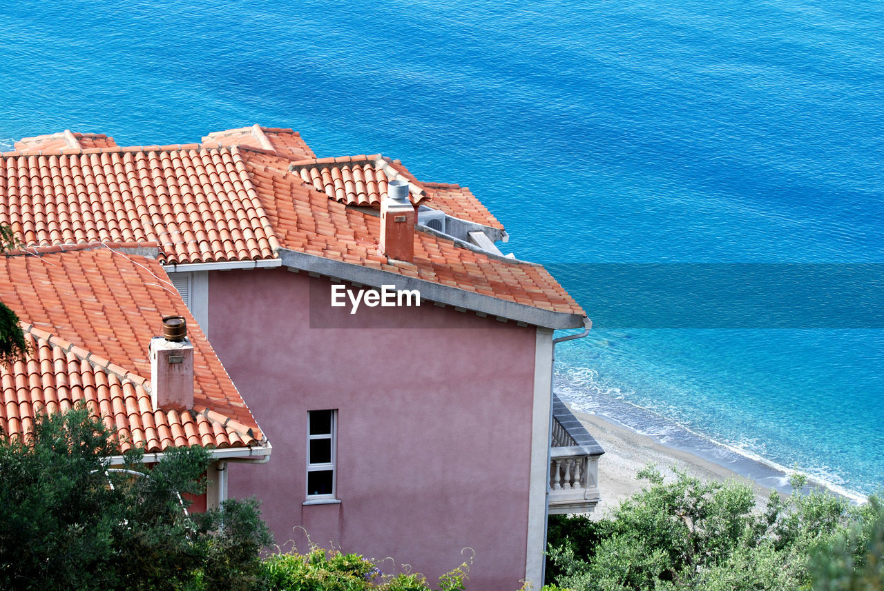 HIGH ANGLE VIEW OF BUILDING BY SEA