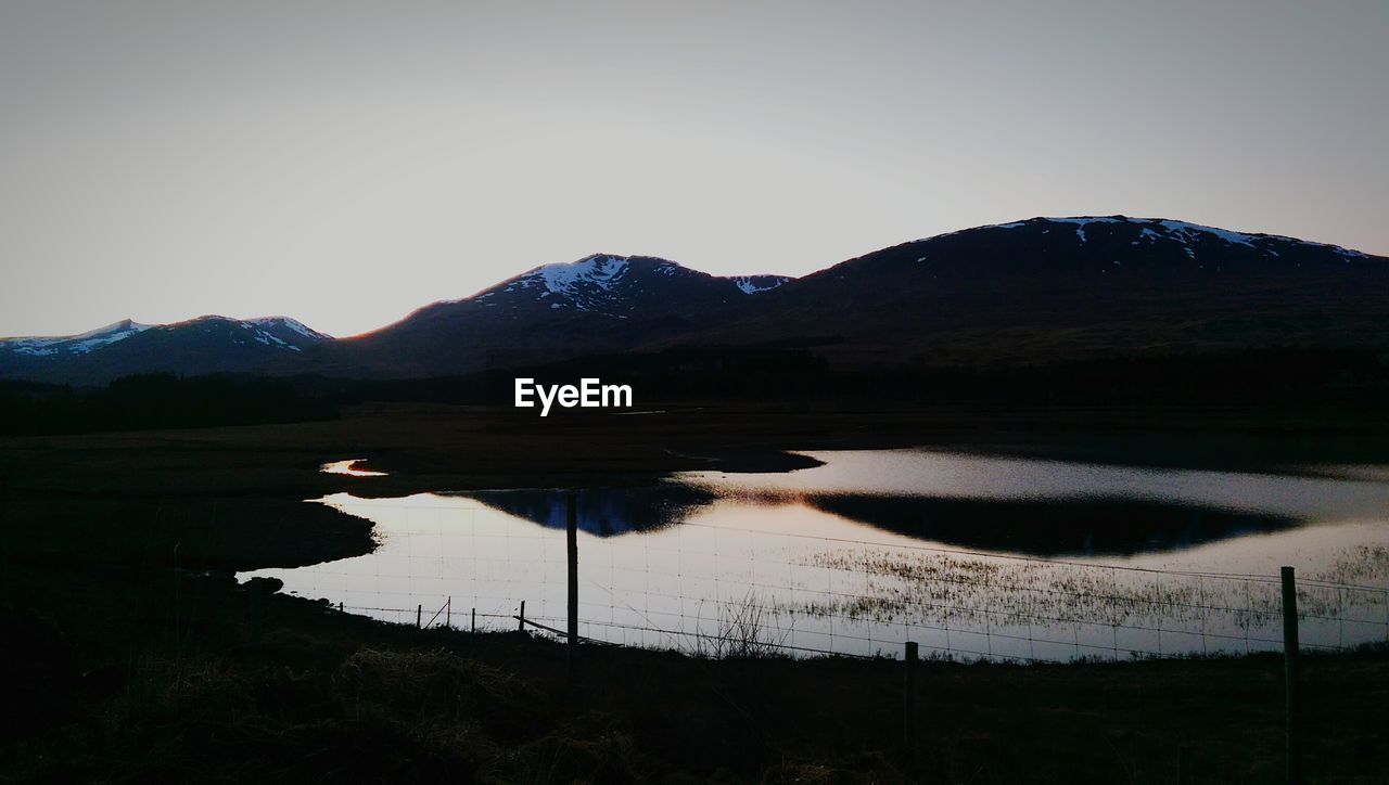 SCENIC VIEW OF LAKE WITH MOUNTAINS IN BACKGROUND