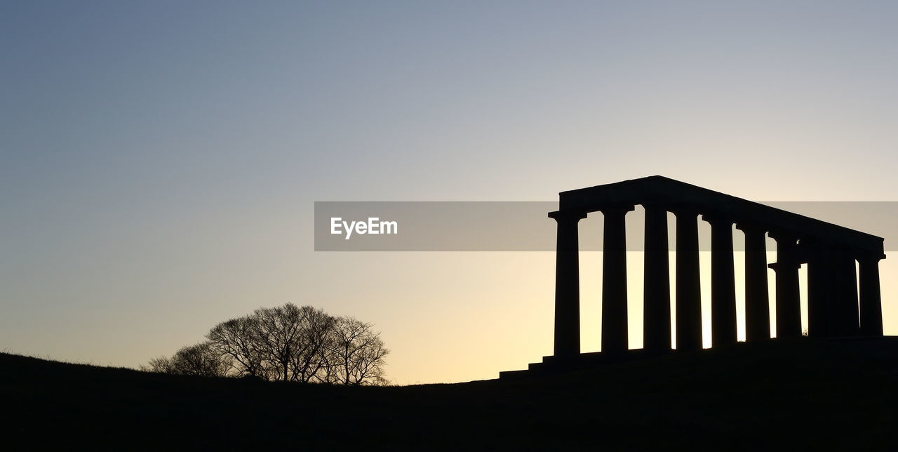 Low angle view of silhouette trees against clear sky