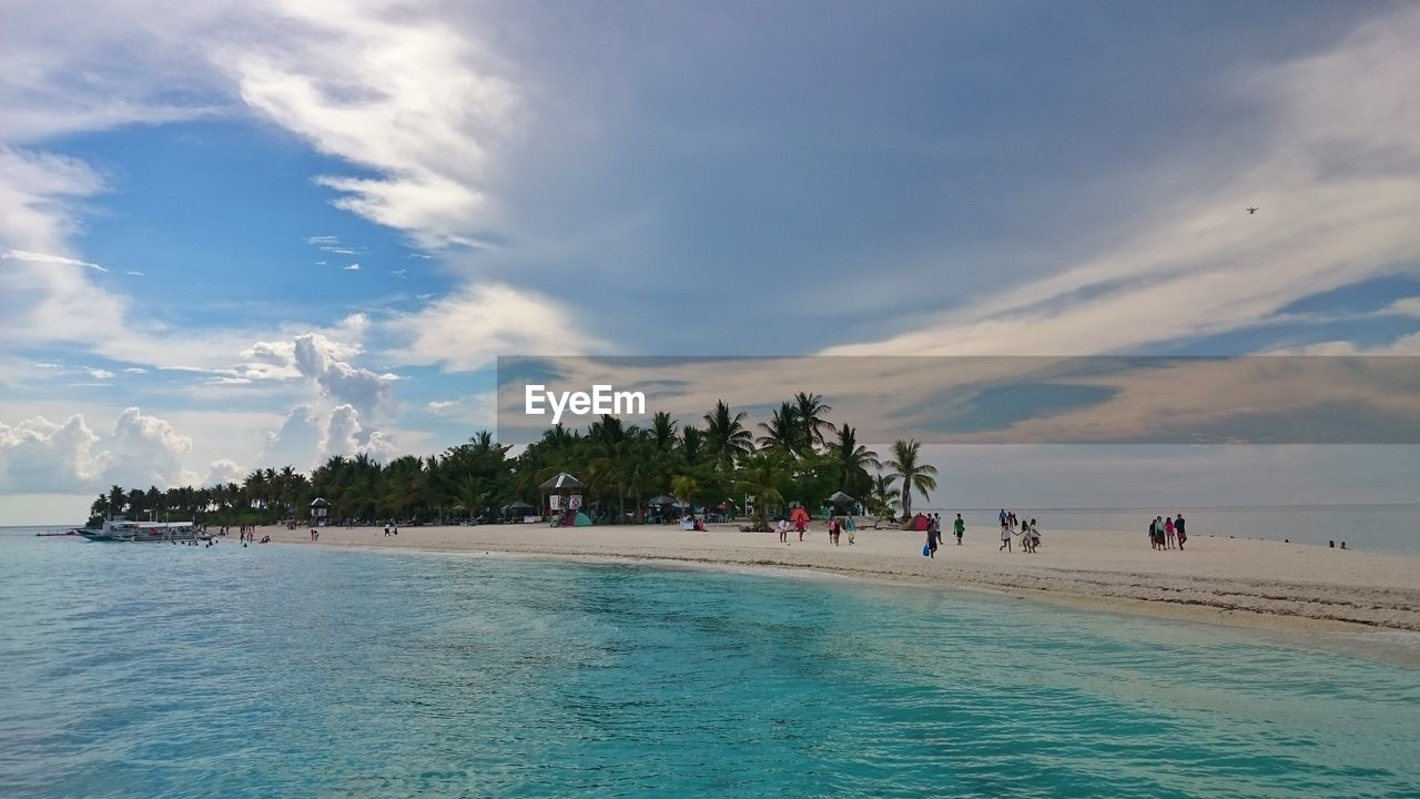 People at beach against sky