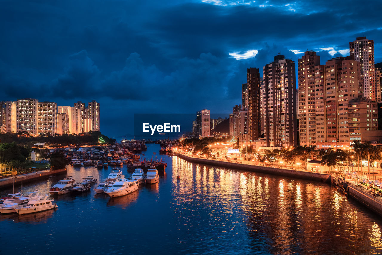 CANAL AMIDST ILLUMINATED BUILDINGS IN CITY AT NIGHT