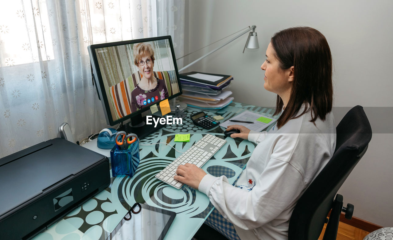 Woman sitting on table at home