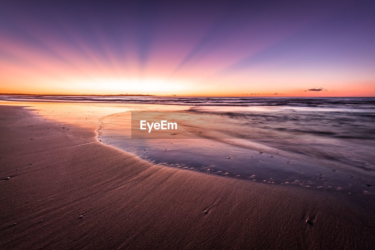 Scenic view of beach against sky during sunset