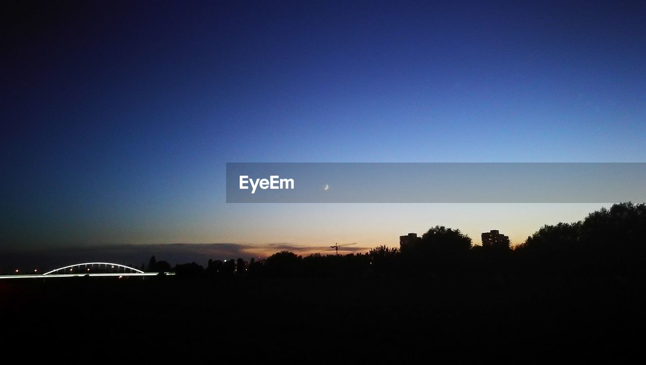 SCENIC VIEW OF SILHOUETTE LANDSCAPE AGAINST CLEAR BLUE SKY AT NIGHT