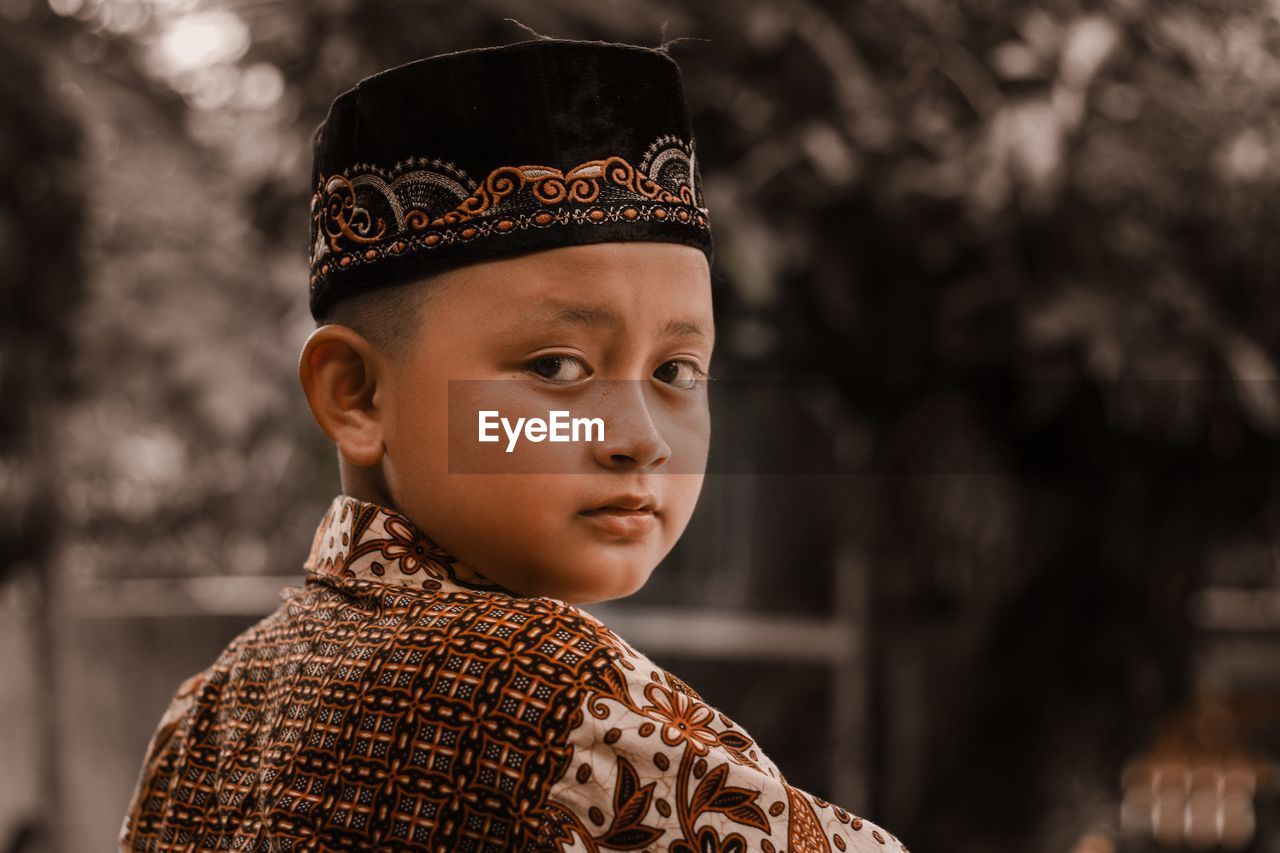 CLOSE-UP PORTRAIT OF BOY LOOKING AT CAMERA