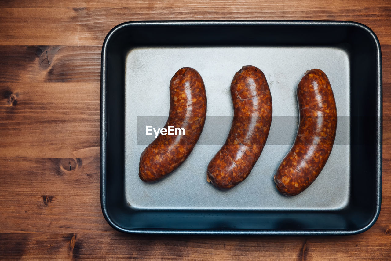 High angle view of roasted sausages in plate on table