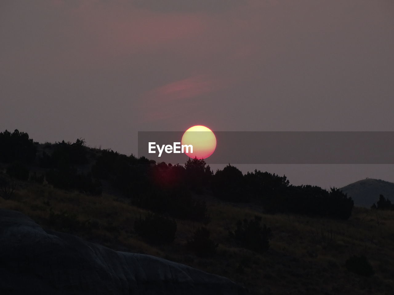 SCENIC VIEW OF SUNSET OVER SILHOUETTE MOUNTAINS