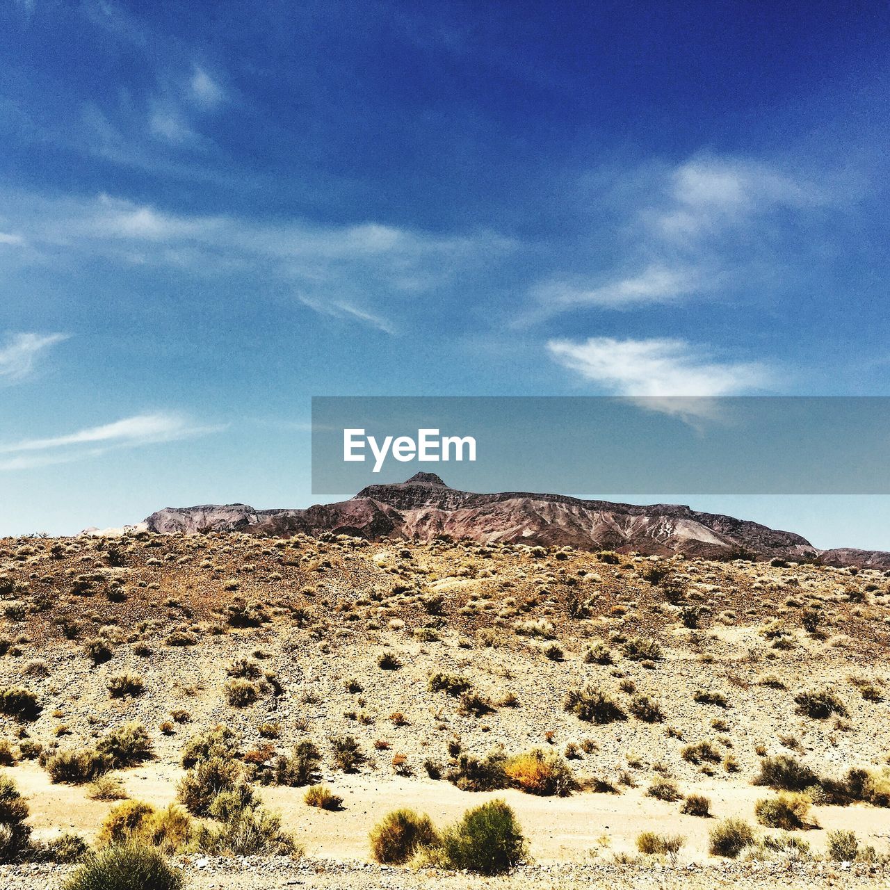 Rocky mountains in desert under blue sky