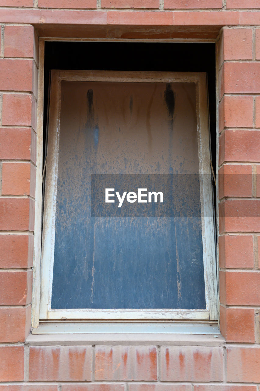 LOW ANGLE VIEW OF WINDOW ON HOUSE WALL