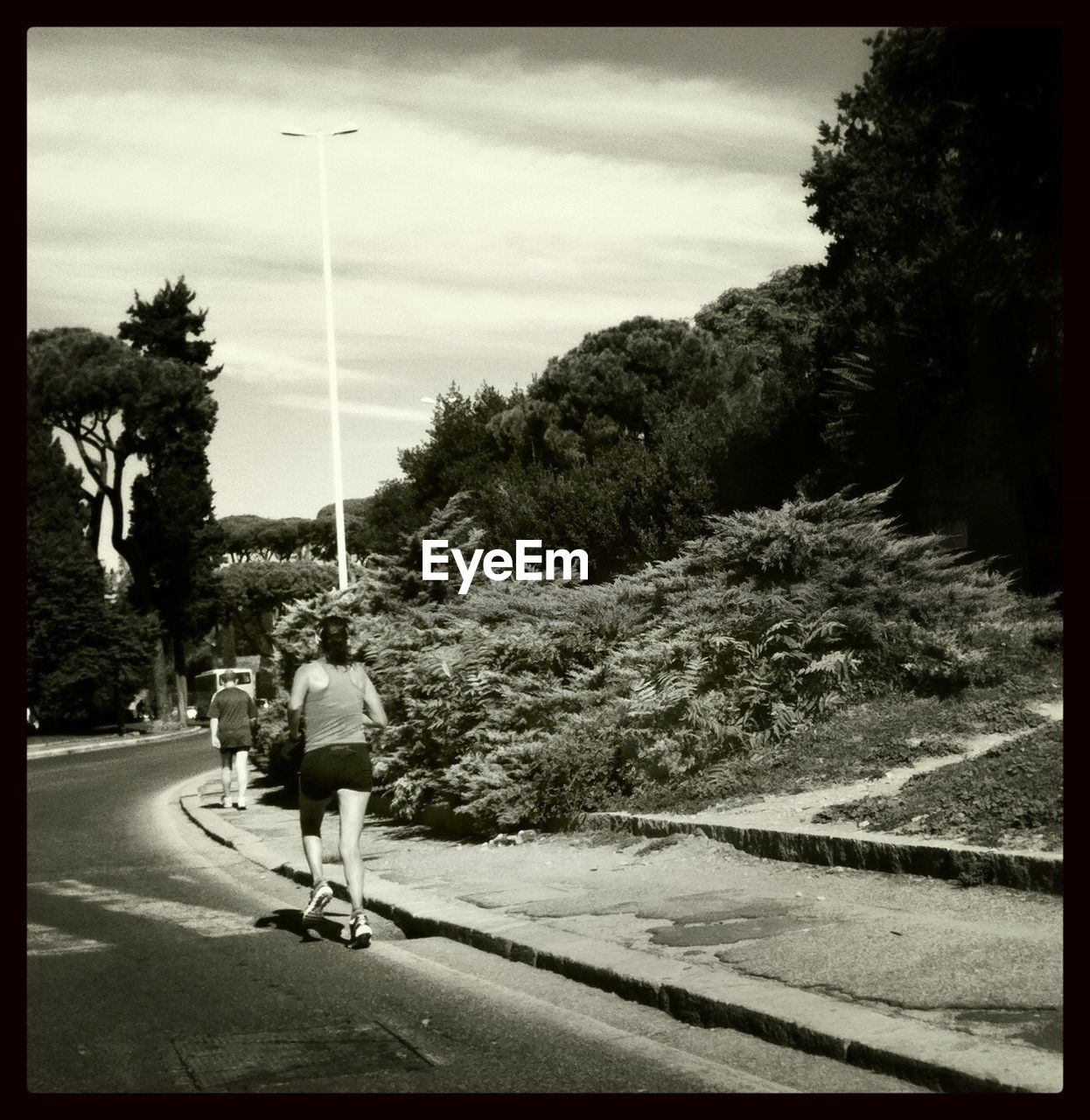 REAR VIEW OF WOMAN WALKING ON ROAD