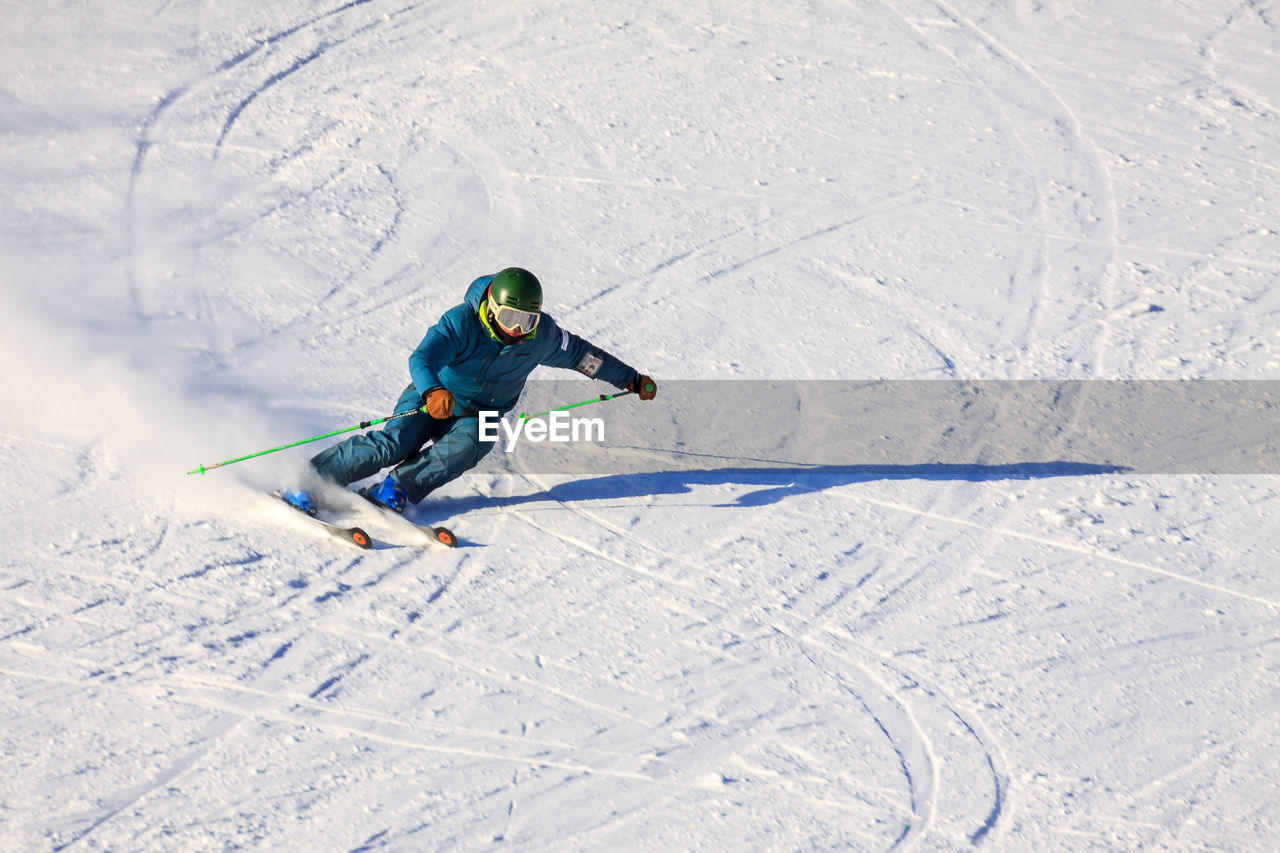 MAN SKIING ON SNOW COVERED LANDSCAPE