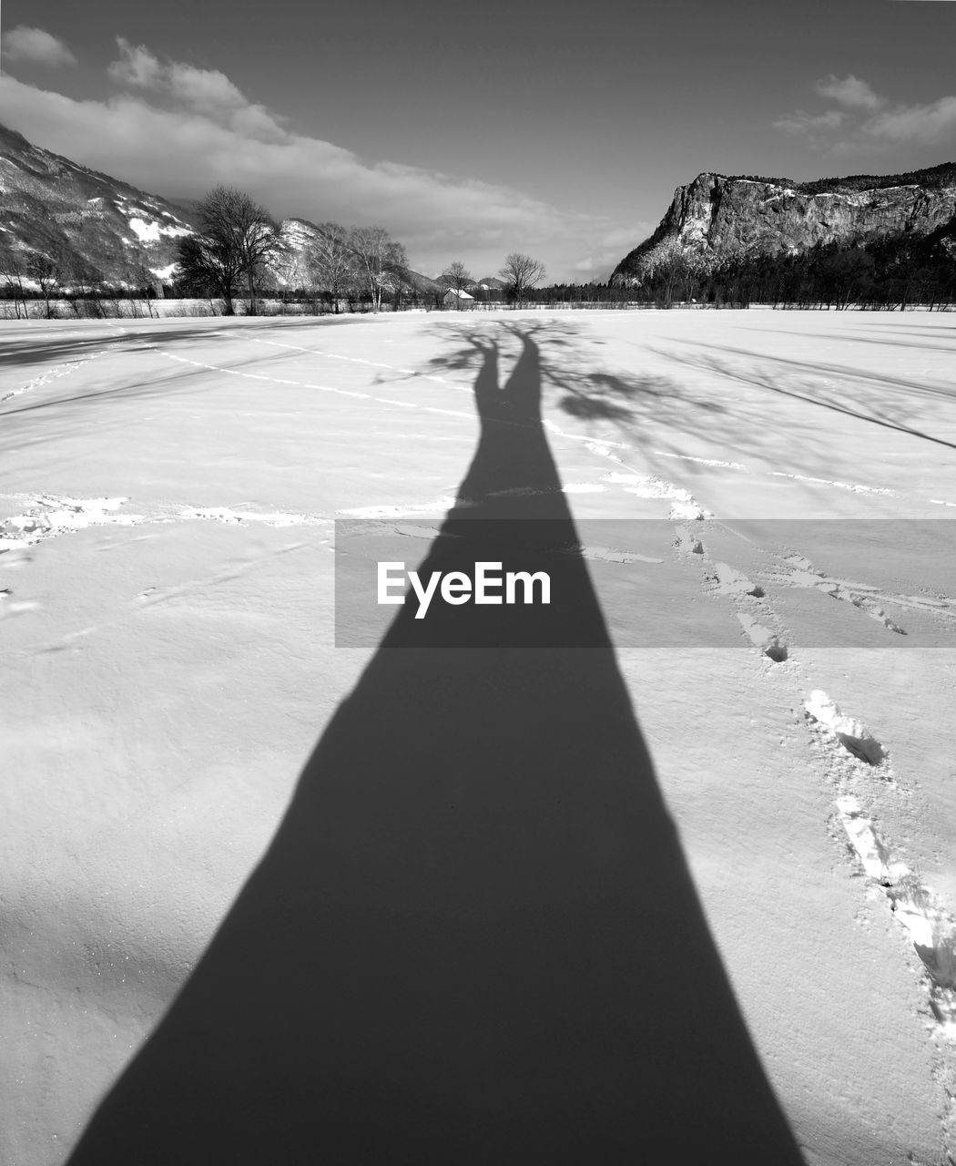 Shadow of man on snow covered landscape