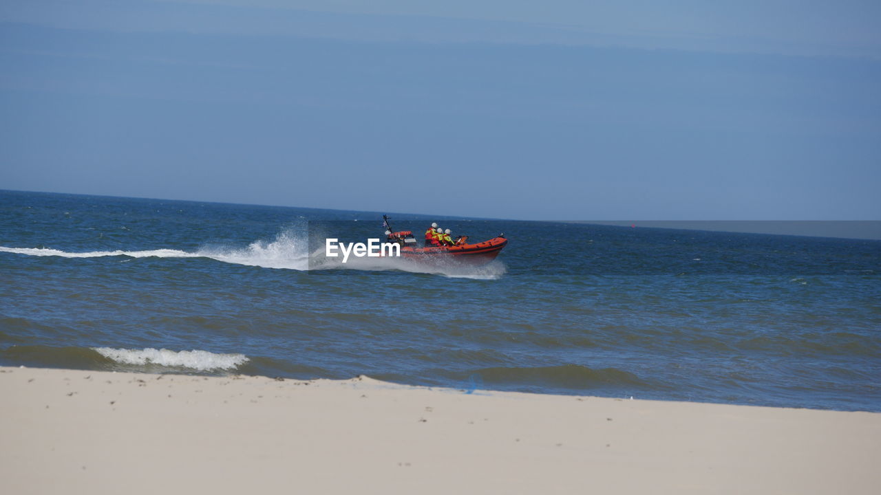 MAN ON BOAT AGAINST SEA