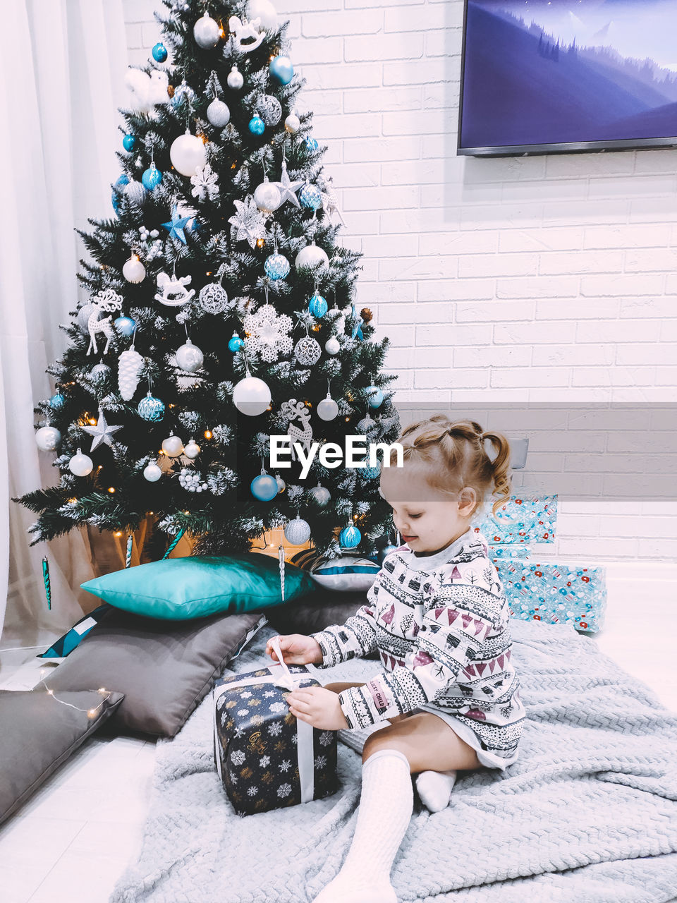 Cute girl sitting on christmas tree