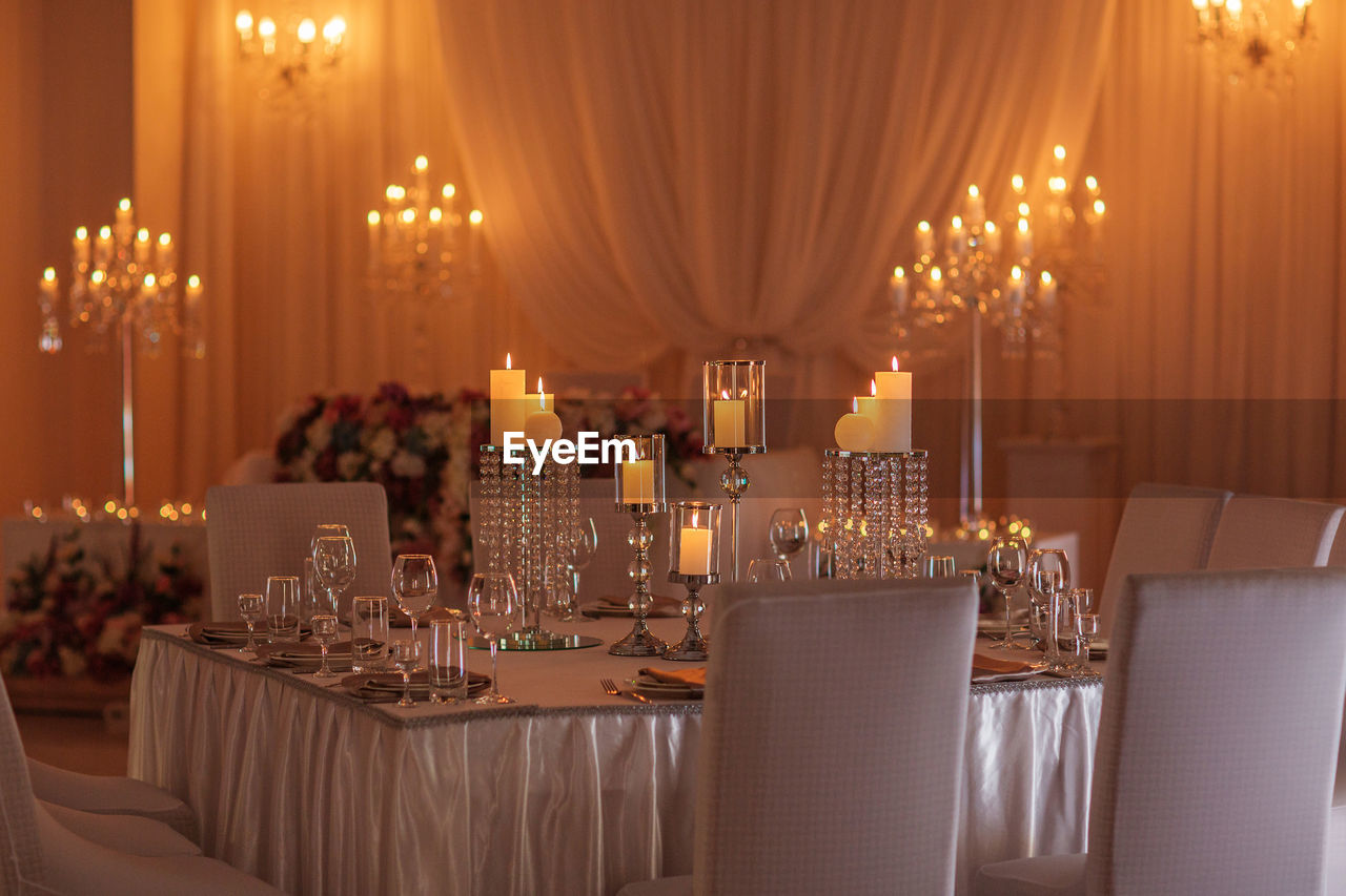 Panoramic view of wine glass on table in illuminated room