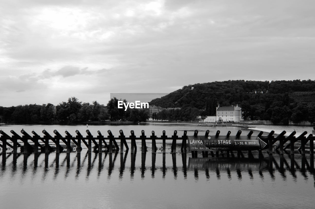 Wooden structure on river against sky