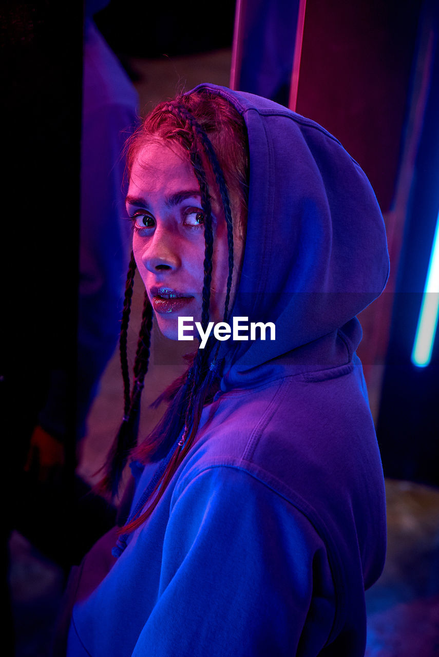 Close-up portrait of young woman in hood 