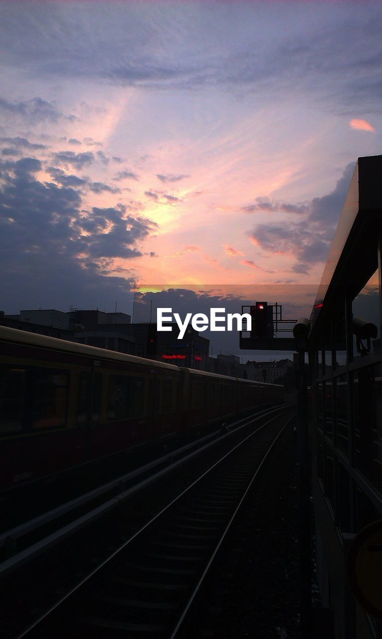 Railroad track against orange sky