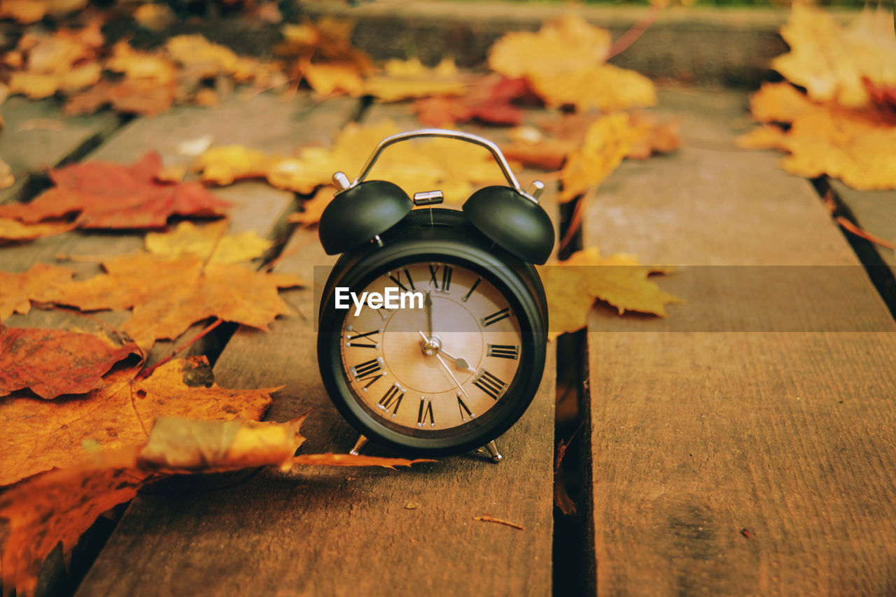 CLOSE-UP OF ORANGE CLOCK ON TABLE