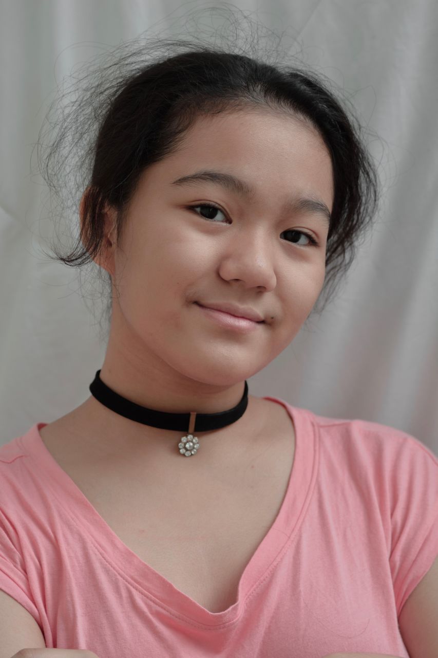 PORTRAIT OF SMILING GIRL IN PINK INDOORS