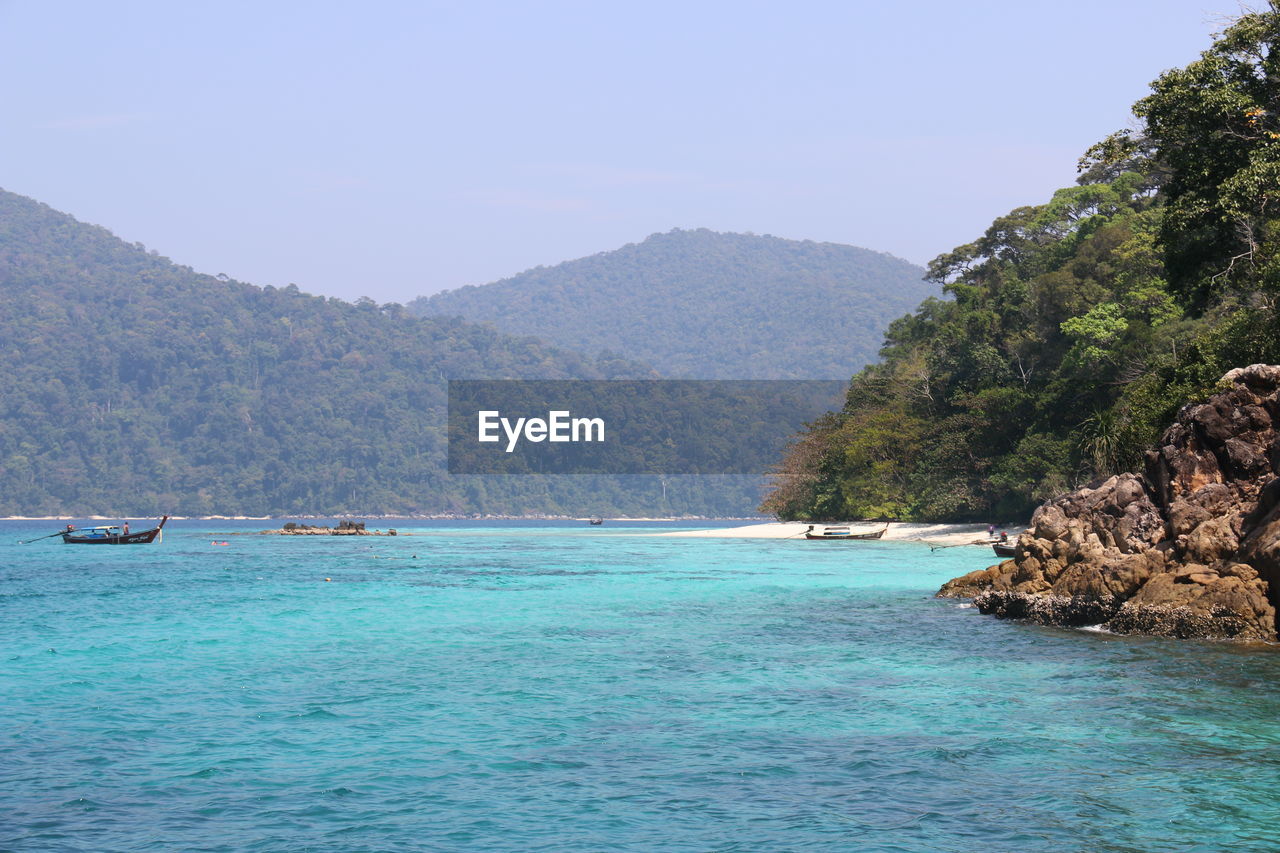 Scenic view of sea and mountains against sky