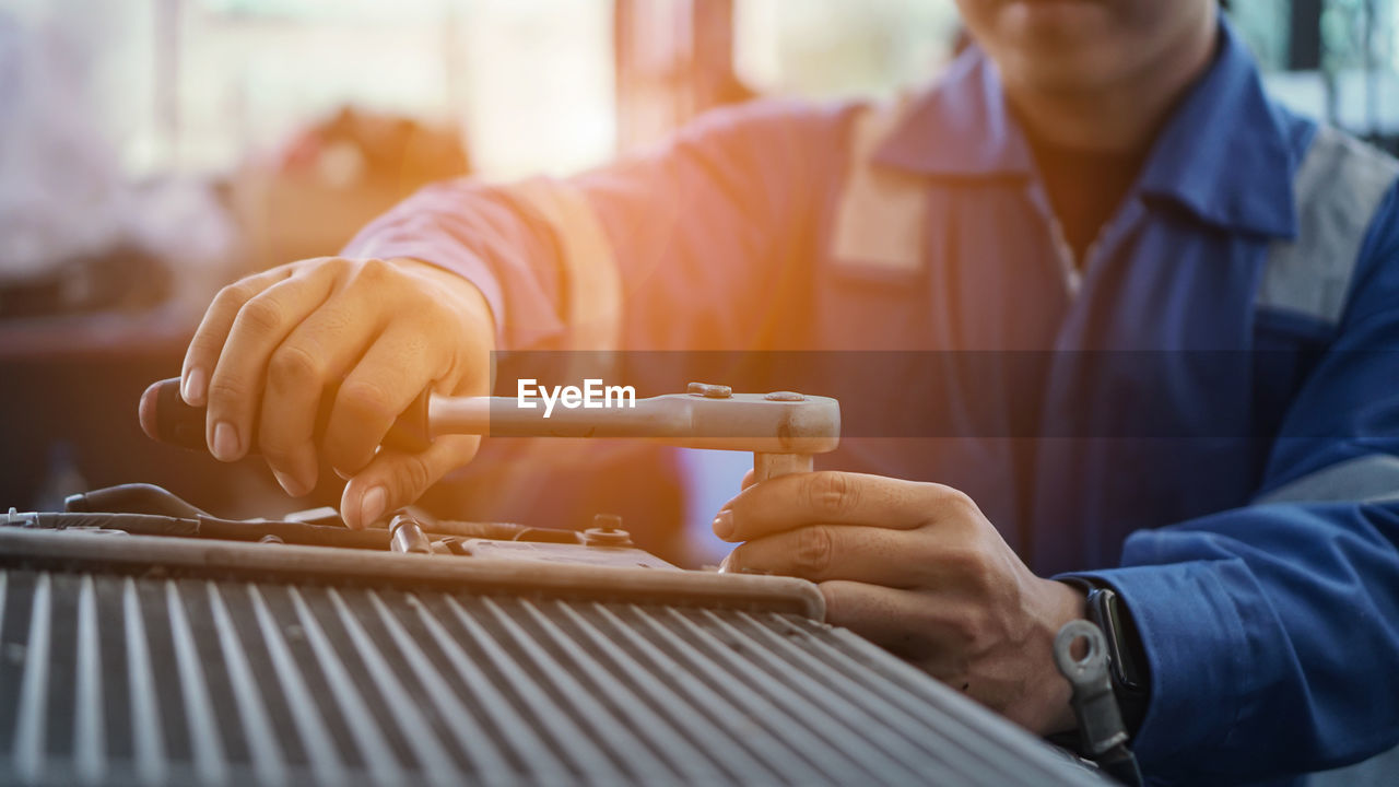 CLOSE-UP OF MAN WORKING AT KITCHEN