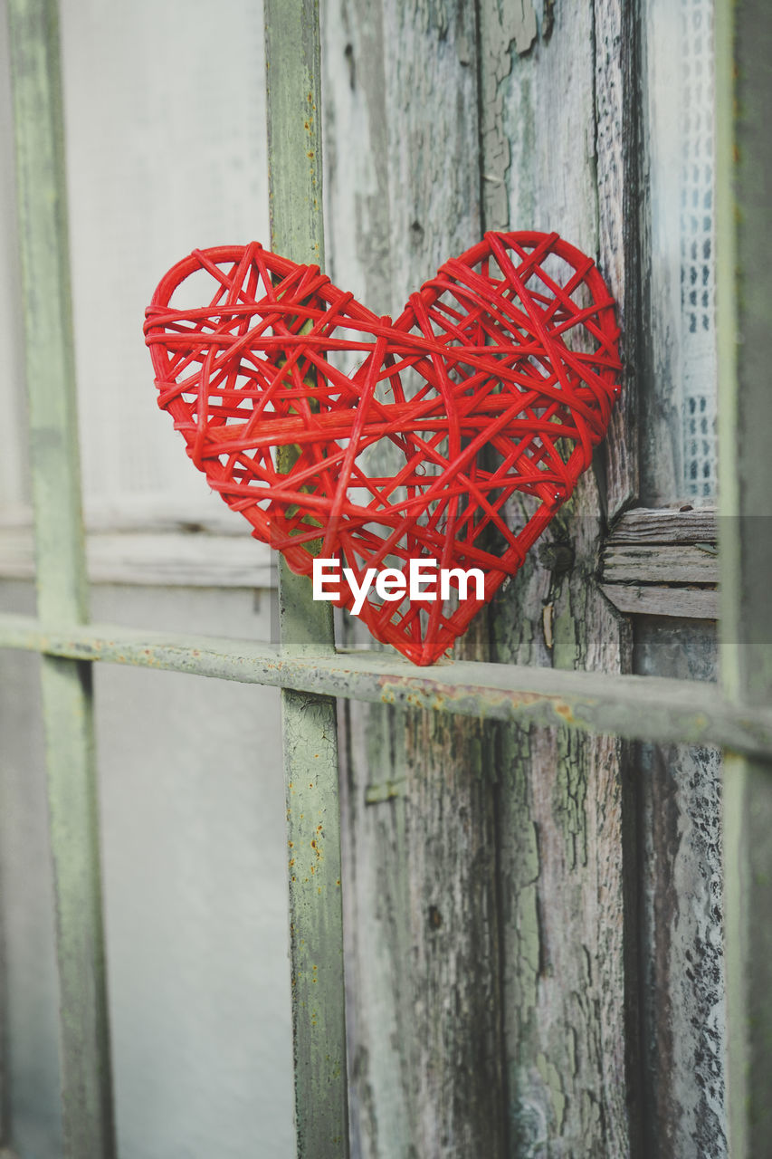 CLOSE-UP OF HEART SHAPE ON WOODEN FENCE