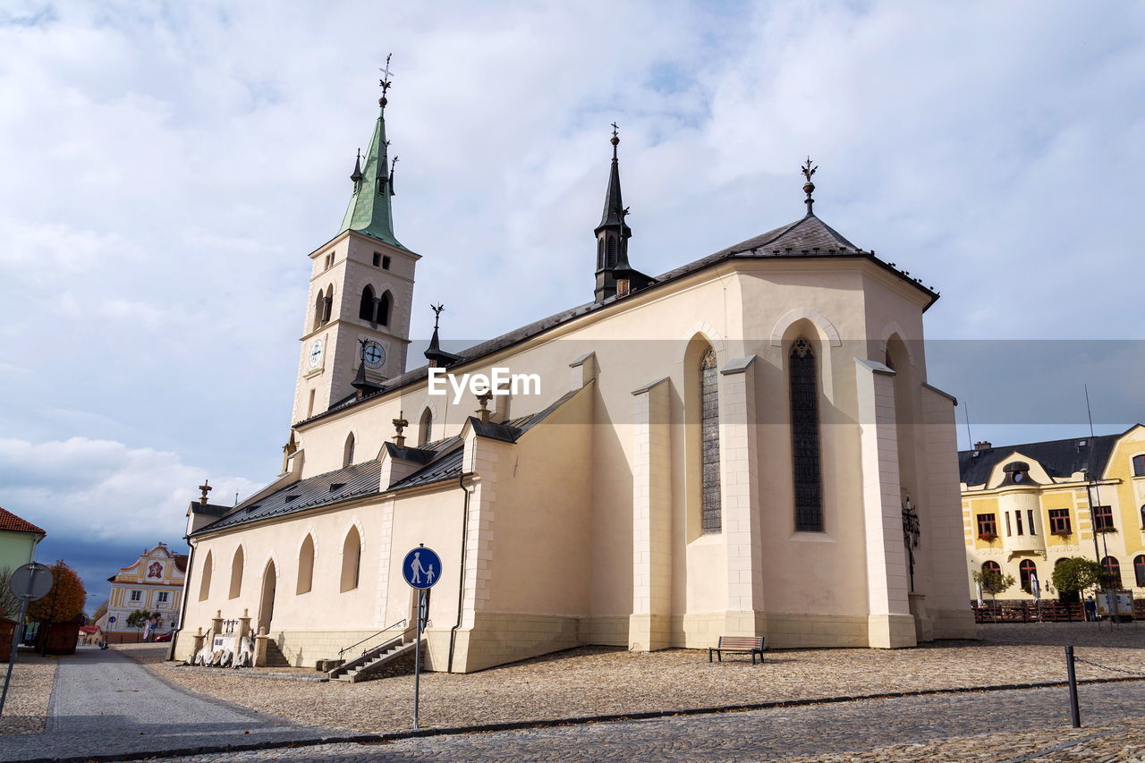 architecture, building exterior, built structure, religion, place of worship, building, belief, sky, travel destinations, town, spirituality, cloud, city, nature, history, the past, travel, catholicism, tower, landmark, tourism, street, worship, no people, day, outdoors, cross, blue, facade, bell tower, old