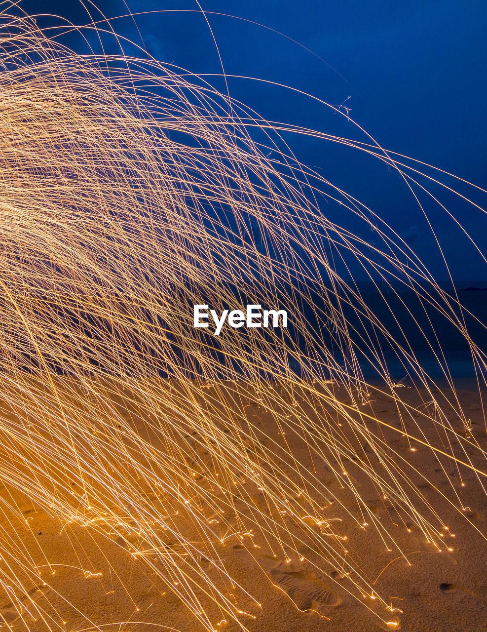 Close-up of fireworks against blue sky