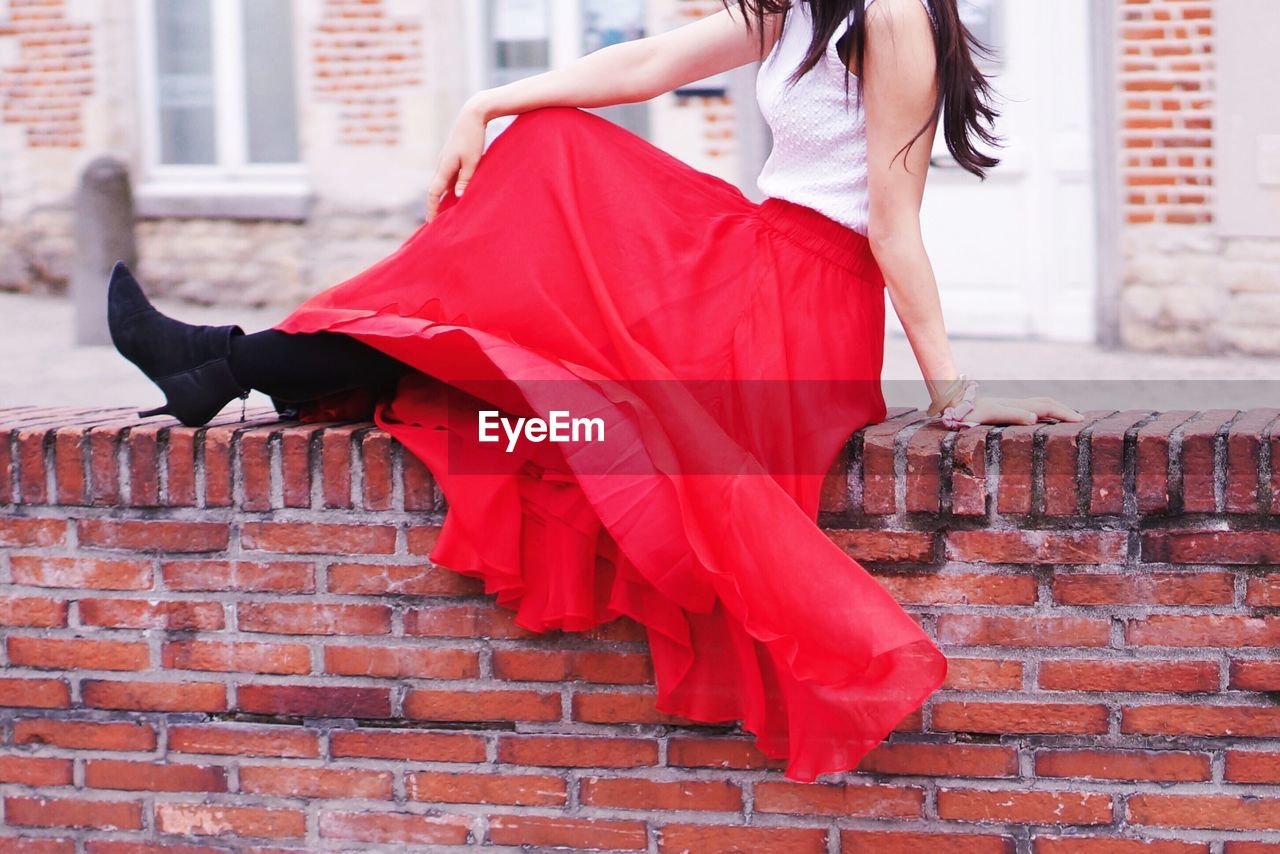 Woman sitting on retaining wall