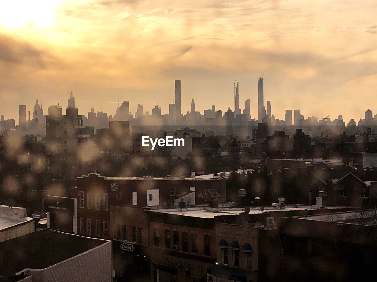 VIEW OF BUILDINGS IN CITY AGAINST SKY DURING SUNSET